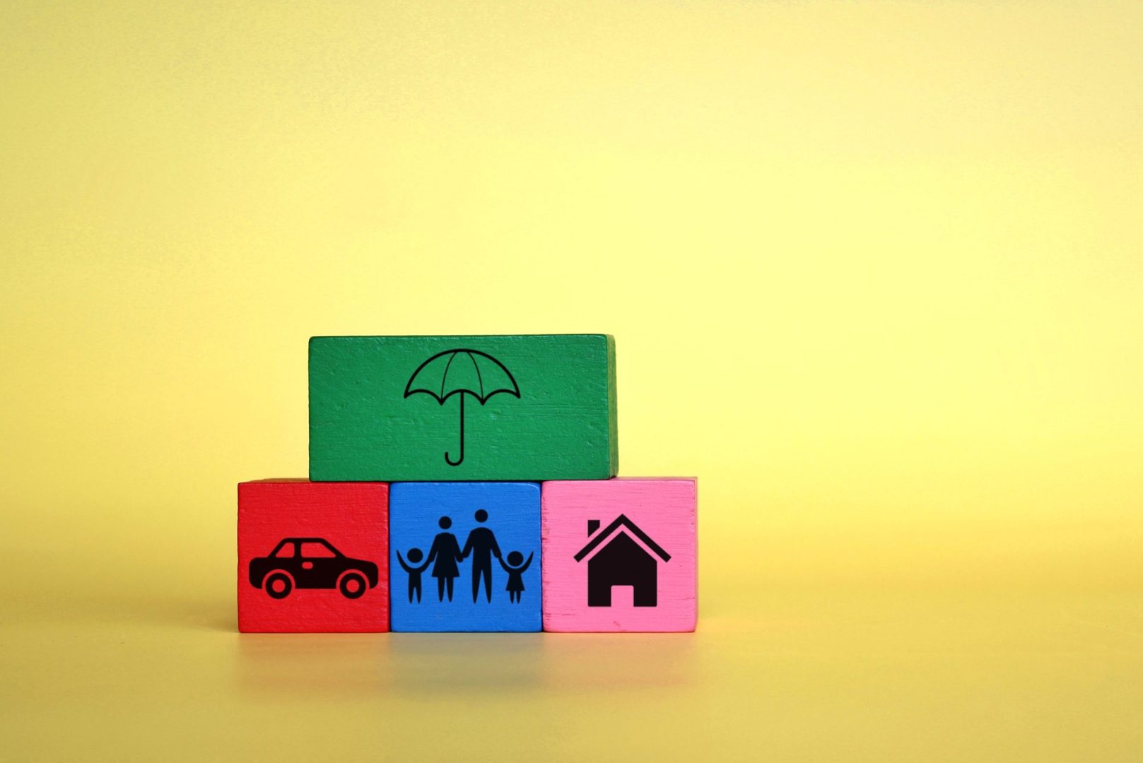 Insurance and protection concept. Wooden cubes with umbrella, car, family and house icon.