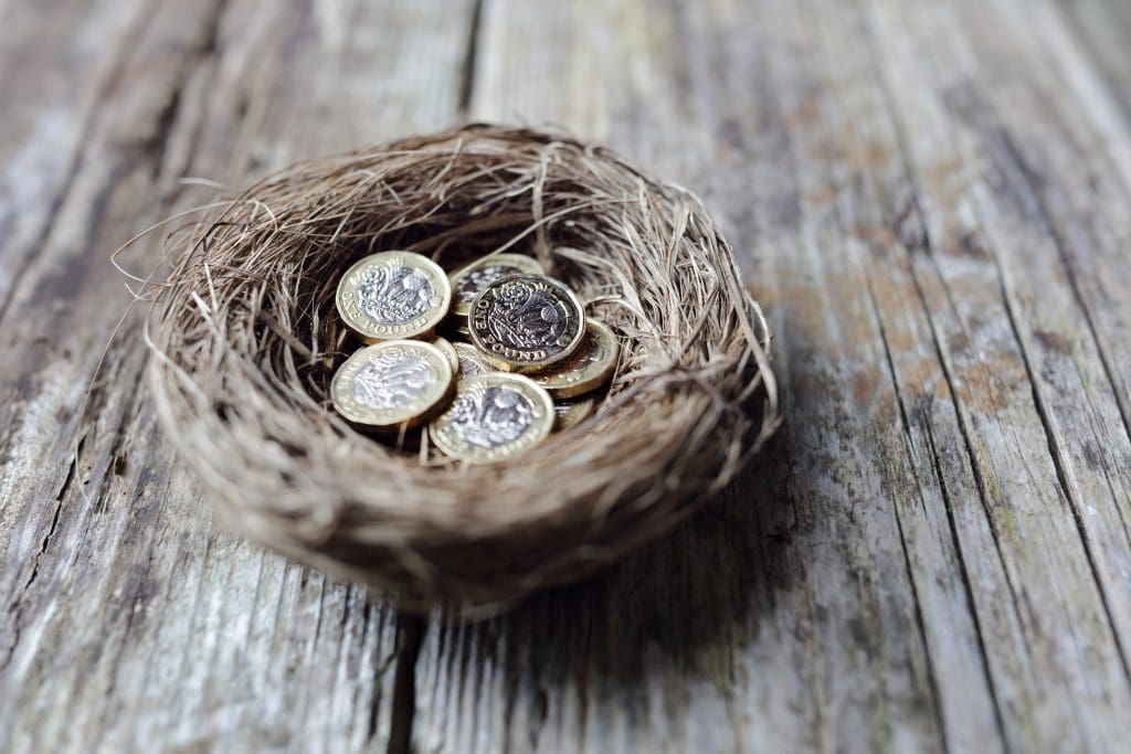 Retirement savings British pound coins in birds nest egg concept for pension plans