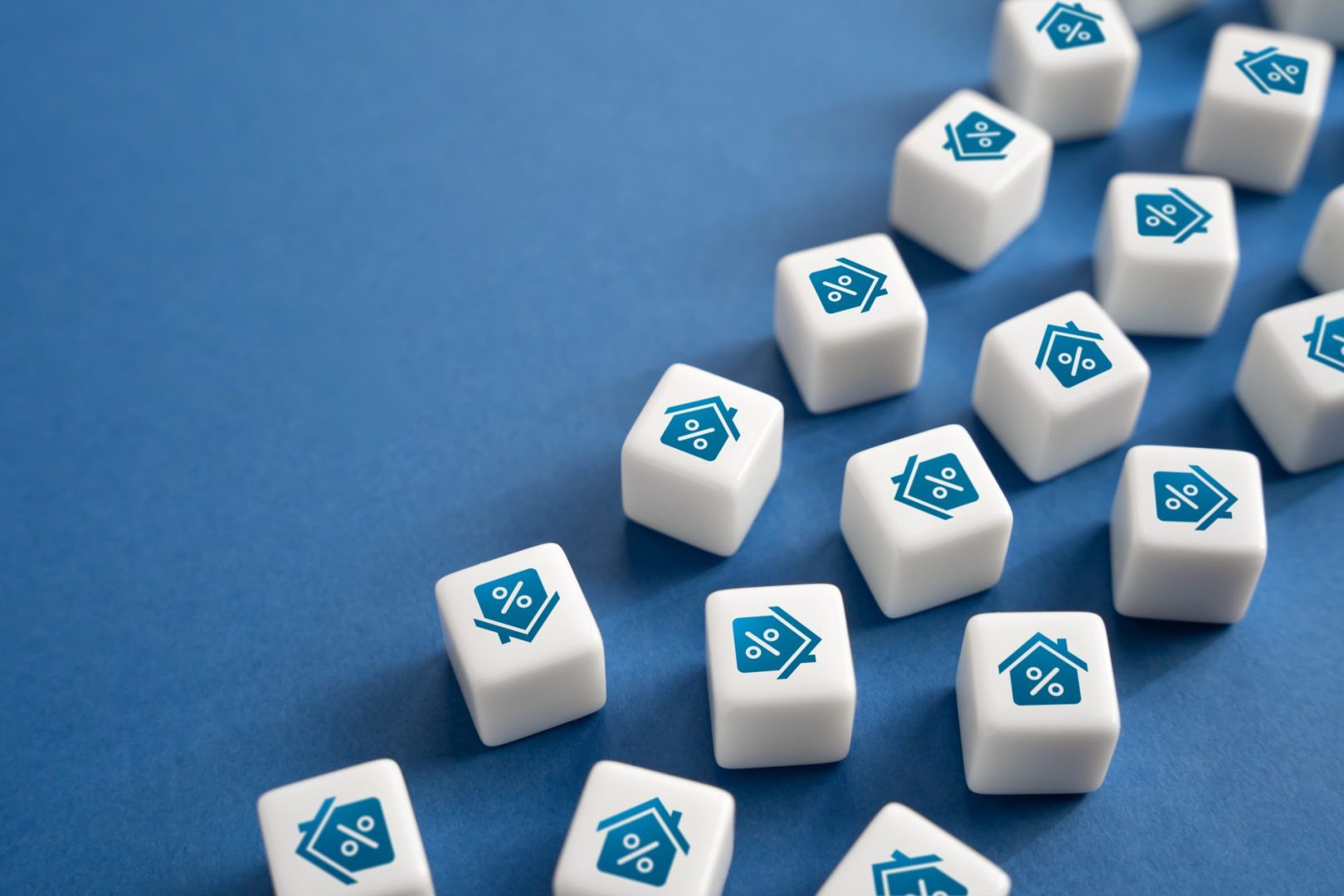 White cubes showing icons of houses with percentage symbols, laid out across a blue surface