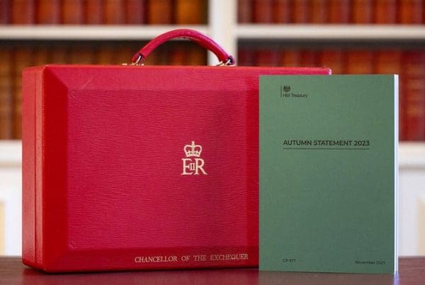 Red briefcase, decorated with Chancellor of the Exchequer Jeremy Hunt's name, next to green book promoting the 2023 Autumn Statement