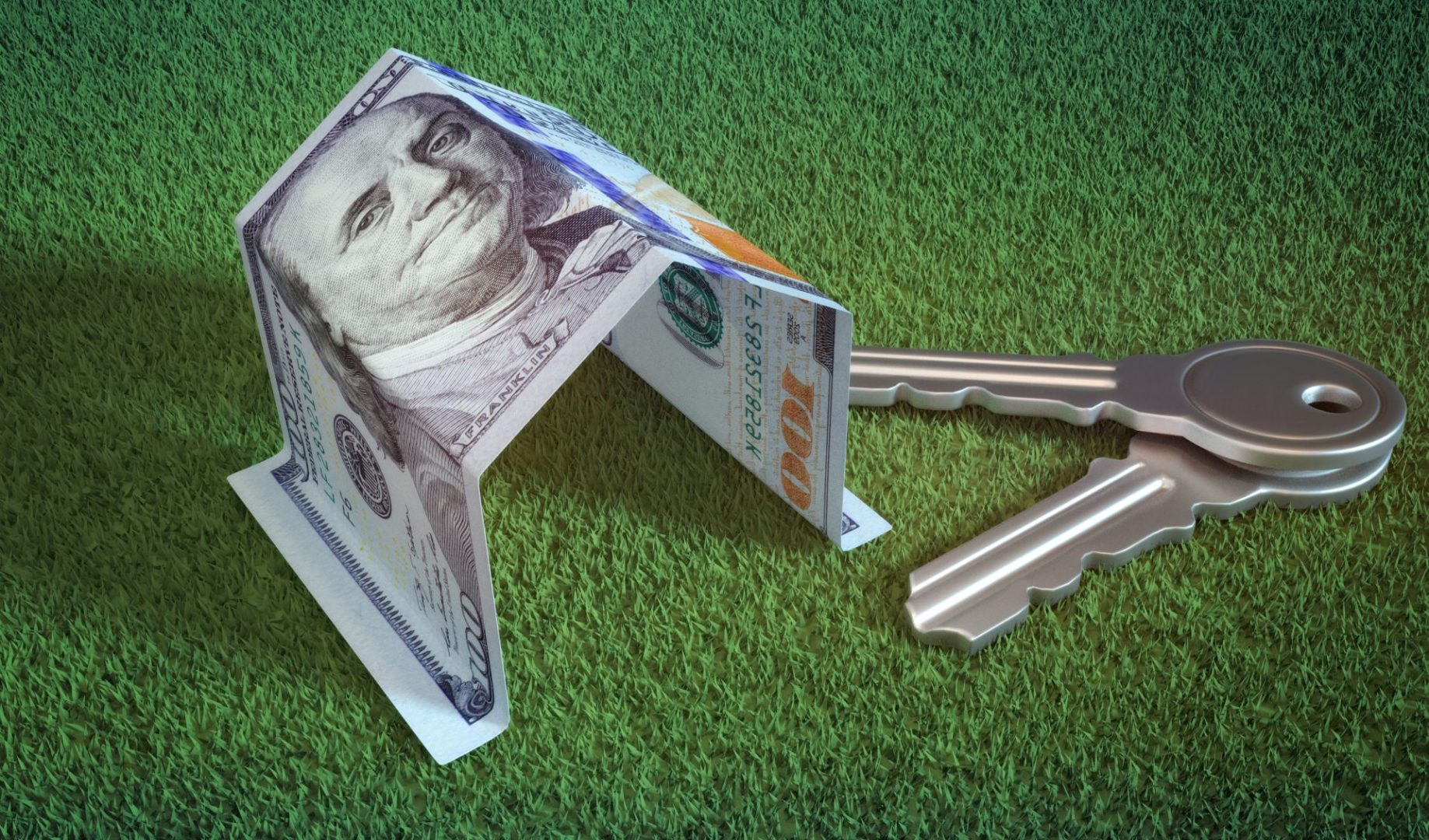 Dollar bill folded into the shape of a house, resting on a green patch of grass next to a set of house keys